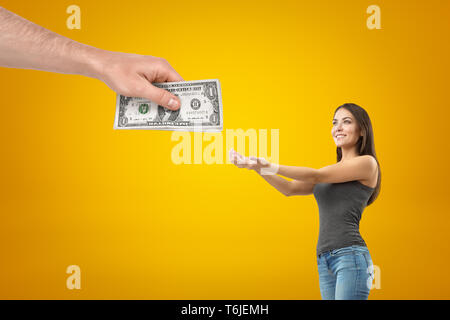 Seite Erntegut Blick auf junge hübsche Mädchen in Freizeitkleidung, halten sich an den Händen Geld aus der Hand des großen Mannes zu nehmen. Stockfoto