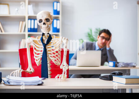 Unternehmer arbeiten mit Skelett im Büro Stockfoto