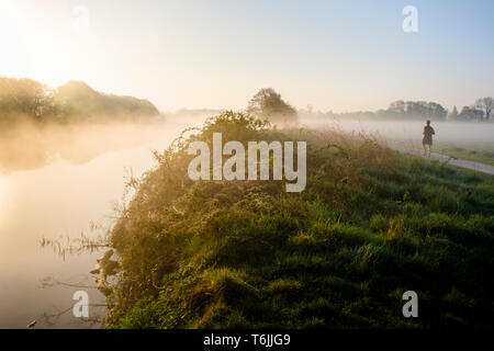 Frühen Morgennebel über dem Fluss Trent und die umliegende Landschaft mit einem Mann laufen, Nottinghamshire, England, Großbritannien Stockfoto