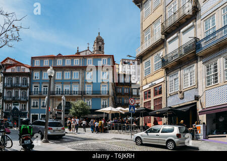 Porto, Portugal - April 29, 2019: die Menschen sitzen in Straßencafés an einem sonnigen Nachmittag im historischen Zentrum von Porto - UNESCO-Welterbe Stockfoto