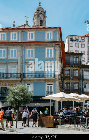 Porto, Portugal - April 29, 2019: die Menschen sitzen in Straßencafés an einem sonnigen Nachmittag im historischen Zentrum von Porto - UNESCO-Welterbe Stockfoto