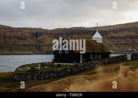 Schwarze hölzerne Kirche von Kaldbak (Kaldbak Kirkja) bei einem stimmungsvollen Abend mit dramatischen Himmel auf Streymoy Insel (Färöer, Dänemark, Europa) Stockfoto