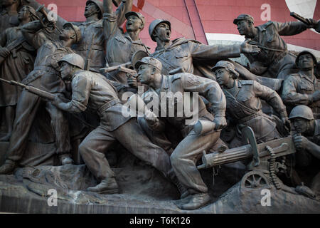 Ein Denkmal auf mansudae Hill in Pjöngjang, Feiern militärischen Sieg über die Japaner und Amerikaner. Die Nordkoreanische Flagge im Hintergrund. Stockfoto