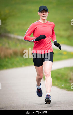 Passen ältere Frau in 50 s die Ausübung und Halten, indem Sie in einem Park anbringen Stockfoto