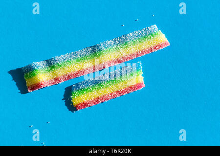 Farbige Marmelade in der Zucker auf dem blauen Hintergrund. Natürliche regenbogenfarbenen Marmelade Süßigkeit. Platz kopieren, leere Vorlage für Text Stockfoto
