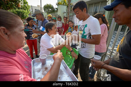Venezolanische Flüchtlinge erhalten Essen auf der Straße in Boa Vista, Brasilien, als Teil einer Not-ernährungsprogramm von Consolata Schwestern geführt wird. Stockfoto