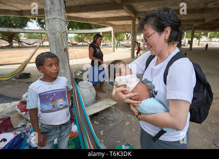 Consolata Schwester Ines Arciniegas hält ein Baby bei einem Besuch in einer Gemeinschaft der Warao indigenen Flüchtlinge aus Venezuela in Boa Vista, Brasilien. Stockfoto