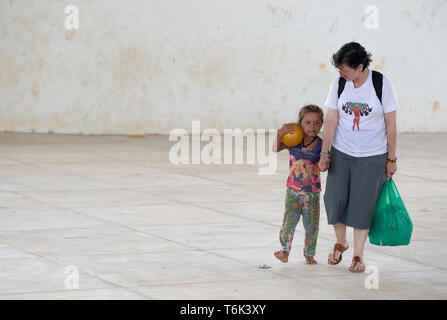 Consolata Schwester Ines Arciniegas Wanderungen mit einem Mädchen bei einem Besuch in einer Gemeinschaft der Warao indigenen Flüchtlinge aus Venezuela in Boa Vista, Brasilien. Stockfoto