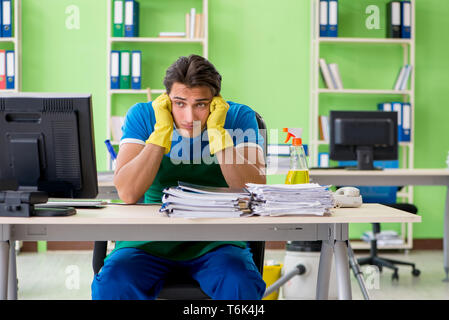 Schöner mann Büro mit Staubsauger reinigen Stockfoto