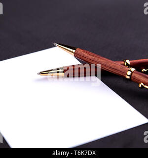 Luxus Kugelschreiber und Druckbleistift in Holz und Gold mit einem weißen Blatt Papier. Stockfoto
