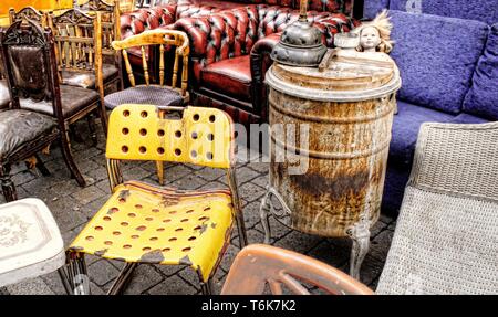 Verschiedene Gegenstände und bric-a-brac außerhalb der zweiten Hand Stall oder Markt, einschließlich einem Stuhl, Sofa, Hocker und brazier Stockfoto