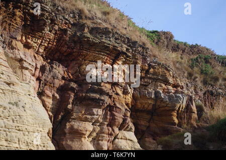 Caiplie Höhlen, Strand Meer Felsen von bunten Karbon Sandstein Geologie von Lisengang Bands und Höhlen betroffen. Anstruther, Fife, Großbritannien. Stockfoto