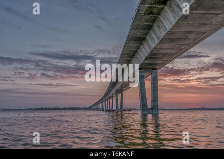 Der Sonnenuntergang und der roten Wolken im Wasser spiegelt unter der Kronprinzessin Mary Bridge, Frederikssund, Dänemark, 30. April 2019 Stockfoto