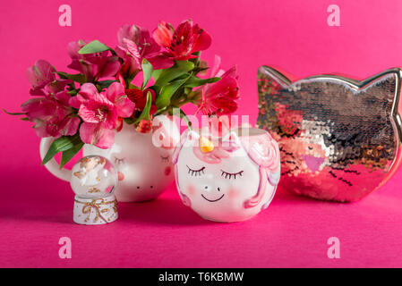 Einhorn Becher mit alstroemeria Blumen und Kitty Bank Stockfoto
