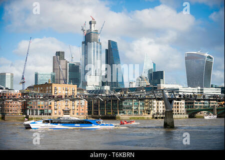 LONDON - November 10, 2018: Ein Thames Clipper Katamaran von mbna Bank geförderte Pässe Wolkenkratzer im Bau im Finanzdistrikt. Stockfoto