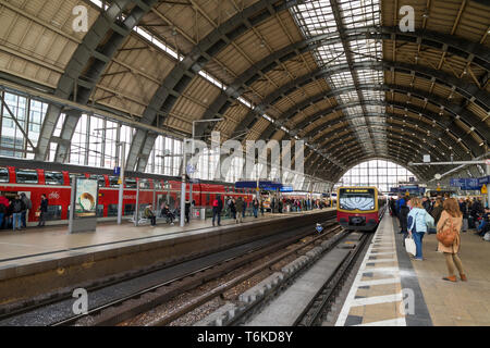 Viele Leute warten auf die Plattform und die S-Bahn an der Haltestelle Alexanderplatz in Berlin, Deutschland. Stockfoto