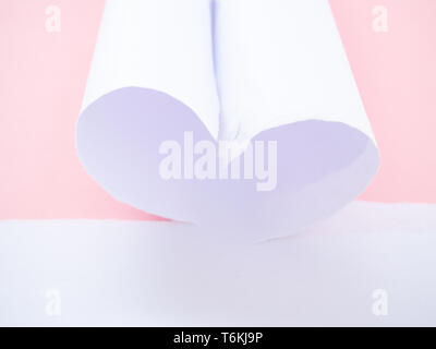 Eine zerrissene White Paper heart-shaped isoliert in Pastell rosa Stockfoto
