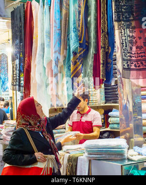 Teheran, Iran - 22. MAI 2017: Frau, Seide, Stoffe, Textilien und bunten Schals im Grand Basar suchen - Hauptmarkt in Teheran Stockfoto