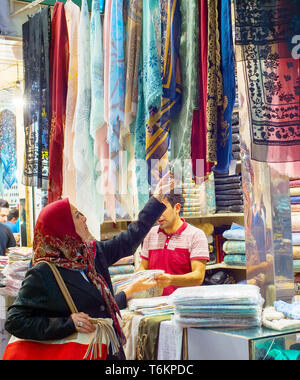 Teheran, Iran - 22. MAI 2017: Frau, Seide, Stoffe, Textilien und bunten Schals im Grand Basar suchen - Hauptmarkt in Teheran Stockfoto