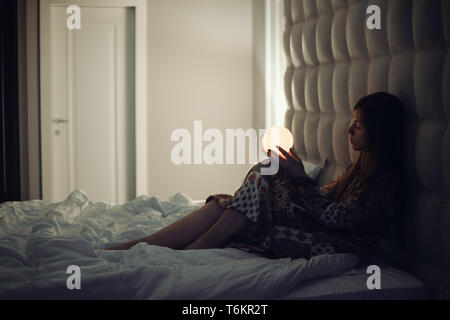 Frau im Bett auf dem Mond Stockfoto