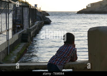 Ein Junge starrte auf das Meer und dachte über sein Leben. Bild von: Adam Alexander/Alamy Stockfoto