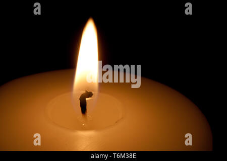 Detail einer brennenden Kerze in der Dunkelheit Stockfoto