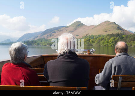 Passagiere auf Keswick Launch Firma Schiff Kreuzung Derwentwater mit Cat Glocken im Hintergrund, Cumbria, England, Großbritannien Stockfoto