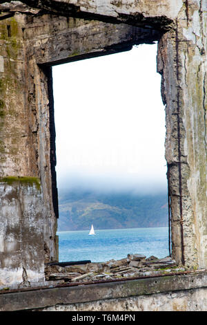 Die Aussicht auf ein Boot segeln aus einem Fenster auf die Insel Alcatraz Stockfoto