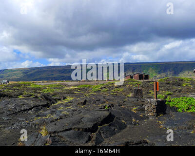 Malerische Aussicht auf einem schwarzen Lava Landschaft mit bewölktem Himmel auf Big Island, Hawaii. Kleine Hütte in den Hintergrund. Stockfoto