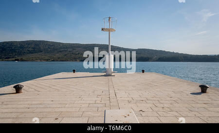 Pier mit Leuchtturm und Poller im Hafen von Cres (Kroatien) Stockfoto