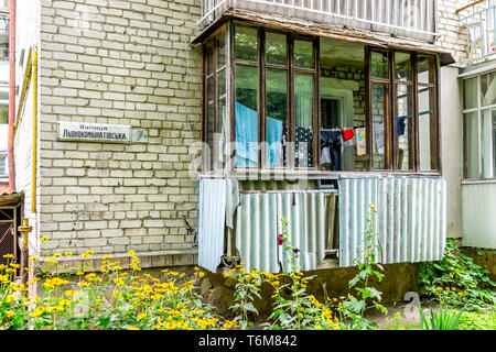 Riwne, Ukraine - Juli 25, 2018: Fenster Balkon auf der unteren Etage der Wohnung ukrainischen Gebäude Sowjetischen alte Wohnung mit Zeichen für Lyonokombinativska S Stockfoto