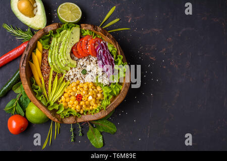 Buddha Schüssel mit Kichererbsen, Avocado, wilder Reis, Quinoa Samen, Paprika, Tomaten, grüne, Kohl, Salat auf schäbige, dunklen steinernen Tisch. Vegetarische fo Stockfoto