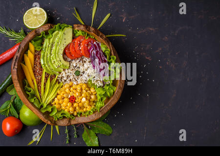 Buddha Schüssel mit Kichererbsen, Avocado, wilder Reis, Quinoa Samen, Paprika, Tomaten, grüne, Kohl, Salat auf schäbige, dunklen steinernen Tisch. Vegetarische su Stockfoto