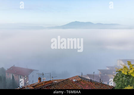 Chiusi Scalo Nebel Nebel Sonnenaufgang auf dem Dach Häuser Gebäude in Italien nahe der Toskana mit weichen Wolken bedeckt, Stadt im Sommer Stockfoto