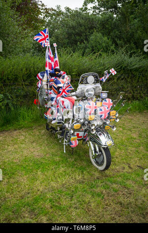 Einen Zeitraum 60er Vespa Roller mit Union Jack Fahnen und Chrom Spiegel eingerichtet. Stockfoto