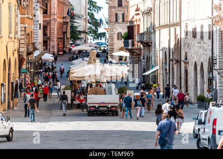 Perugia, Italien - 29 August 2018: Straßenbild des historischen alten mittelalterlichen Etruskischen Gebäuden der Stadt Dorf gelben Farben im Sommer mit Cafe Restaurant. Stockfoto