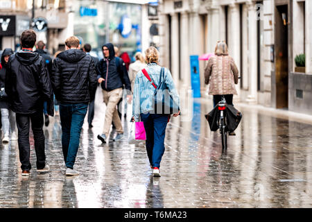 London, Großbritannien - 12 September 2018: Wieder von vielen Menschen zu Fuß im verregneten Stadt Wetter auf nasser Fahrbahn Gehweg Straße Reflexion Einkaufen in SoHo Stockfoto