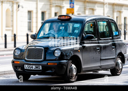 London, UK, 14. September 2018: Pimlico Bereich closeup von teuren schwarzen Taxi und Treiber auf der Straße Straße Mann hinter Rad wartet im Verkehr Stockfoto