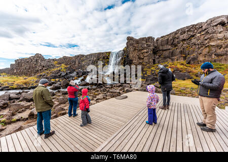 Thingvellir, Island - 20. September 2018: Nationalpark Oxararfoss Wasserfall felsige Landschaft auf Golden Circle mit Wasser Fluss und touristische Menschen tak Stockfoto