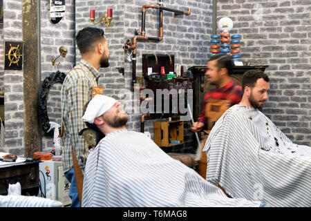 Blick in das Innere des Friseursalons, Männer, die auf Barbersesseln sitzen Portugiesischer Friseursalon trimmt Kunden Bärte in Lissabon Portugal EU KATHY DEWITT Stockfoto