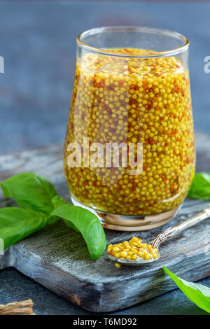 Senf Sauce im Glas und frischem Basilikum. Stockfoto