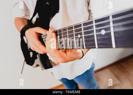 Nahaufnahme der Hand eines Gitarristen der Performance eines Songs drücken Sie gleichzeitig auf den Saiten. Stockfoto