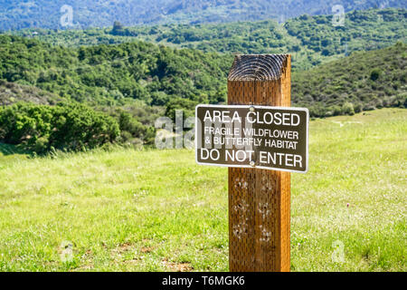 'Bereich geschlossen Fragile Wildflower & Schmetterling Lebensraum; Nicht betreten" Schild auf den Hügeln von San Francisco Bay Area in einem County Park, Kalifornien Stockfoto