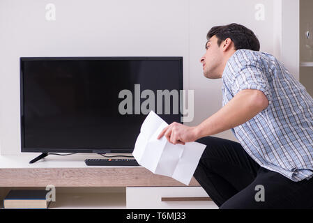 Mann, der versucht, defekte Fernseher zu reparieren Stockfoto