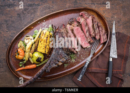 Traditionelle Grill trockenen Jahren geschnitten Wagyu tomahawk Steak mit gegrilltem Gemüse als Draufsicht auf einer Platte Stockfoto