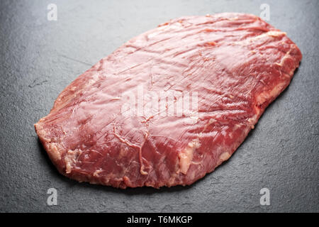 Raw trockenen Jahren wagyu Flank Steak als Draufsicht auf einem schwarzen Brett Stockfoto