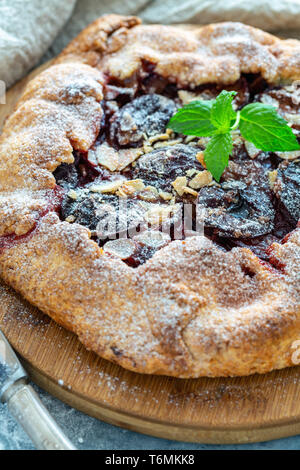 Obst Kuchen mit Pflaumen, Mandelflocken und Minze. Stockfoto