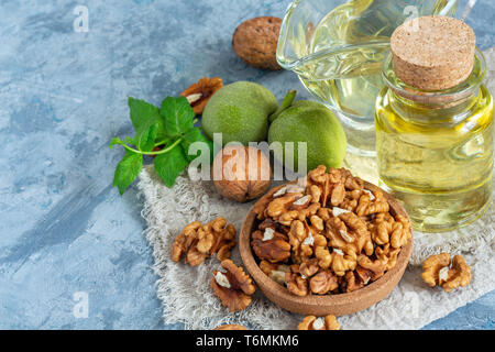 Walnussöl in eine Flasche und ein Glas Schale. Stockfoto