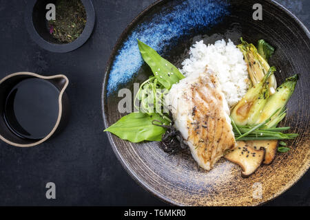 Moderne japanische Frittierter Kabeljau Filet mit bok Choi und Reis in der Ansicht von oben in eine Schüssel geben. Stockfoto