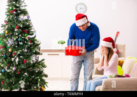 Junges Paar Weihnachten zu Hause feiern. Stockfoto